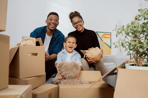 Família amorosa desempacota várias caixas ao redor deles depois de se mudar para um novo apartamento