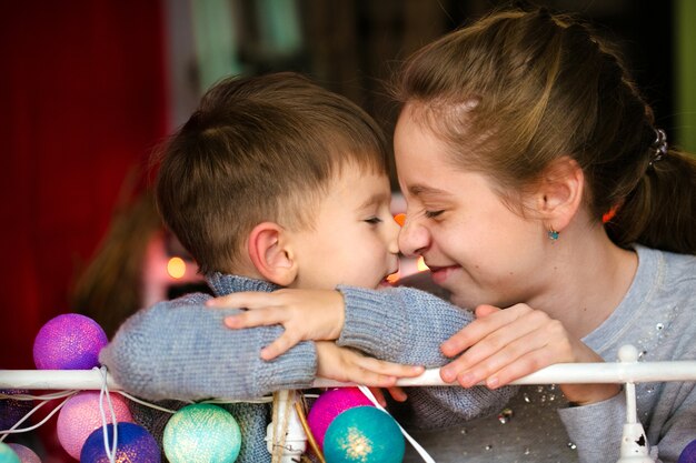 Família amorosa e feliz sentada ao lado do mau e sorrindo irmão e irmã se divirtam