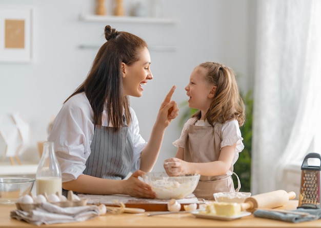 Família amorosa feliz está preparando a padaria juntos Mãe e filha filha estão cozinhando biscoitos e se divertindo na cozinha Comida caseira e ajudante