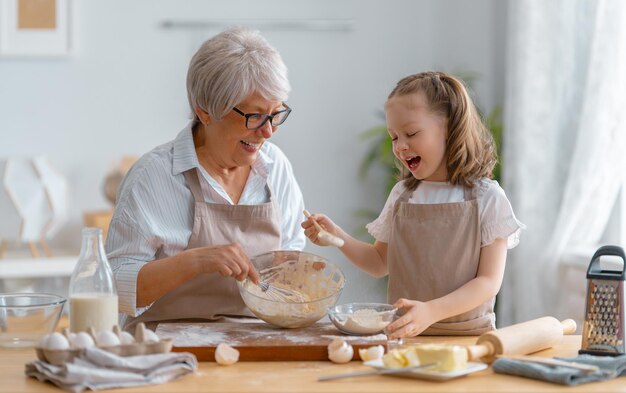 Família amorosa feliz está preparando a padaria juntos vovó e