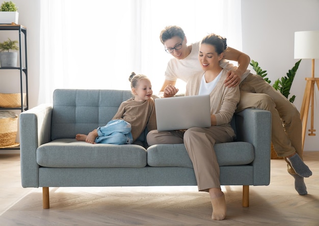 Família amorosa feliz Jovem mãe pai e filha usando laptop