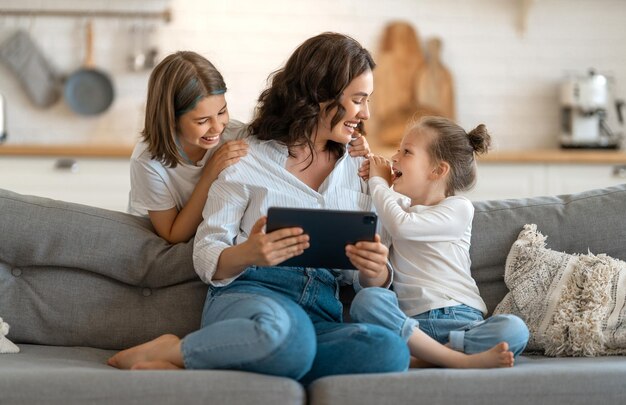 Familia amorosa feliz Madre joven e hijas niñas usando tablet pc para conversación remota