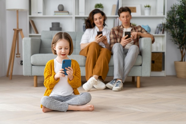 Familia amorosa feliz Madre joven padre e hija usando teléfonos