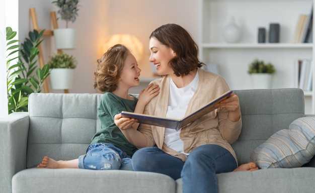 Família amorosa feliz muito jovem mãe lendo um livro para sua filha