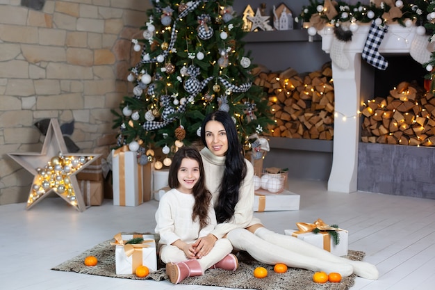 Familia amorosa con regalos en casa por árbol de Navidad