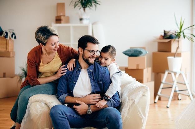 Família amorosa relaxando na sala de estar de sua nova casa