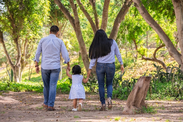 Família andando de mãos dadas em um parque no Peru