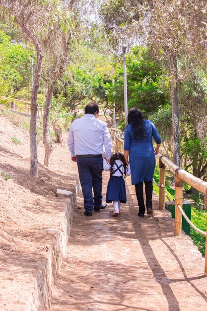 Família andando de mãos dadas em um parque no Peru