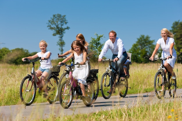Família, andar de bicicleta ao ar livre no verão