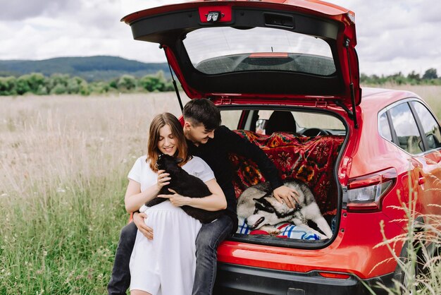 Familia con animales en la naturaleza al fondo de su auto