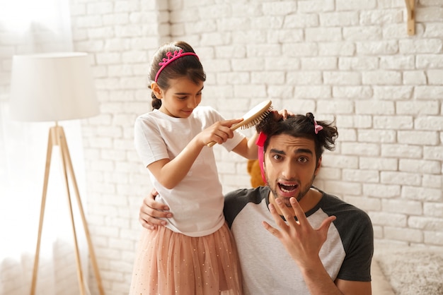 Família árabe garota está fazendo novos pais penteado para papai