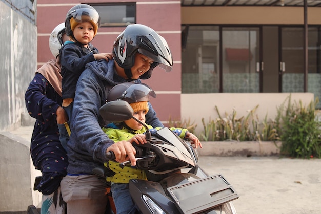 Foto família asiática andando de moto scooter juntos viajando com crianças