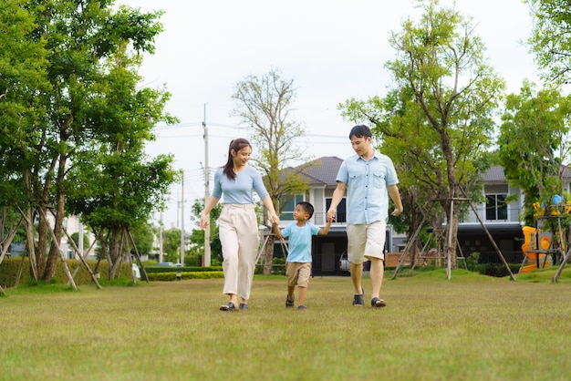 Família asiática andando no quintal ou parque público no bairro para saúde e bem-estar diário, família feliz física e mental.