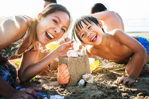 Família asiática brincando na praia