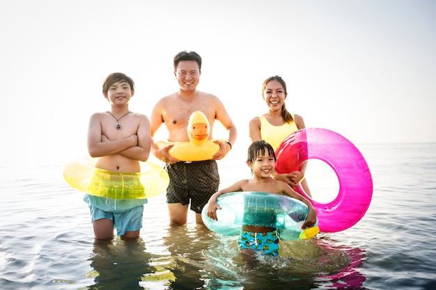 Família asiática brincando na praia