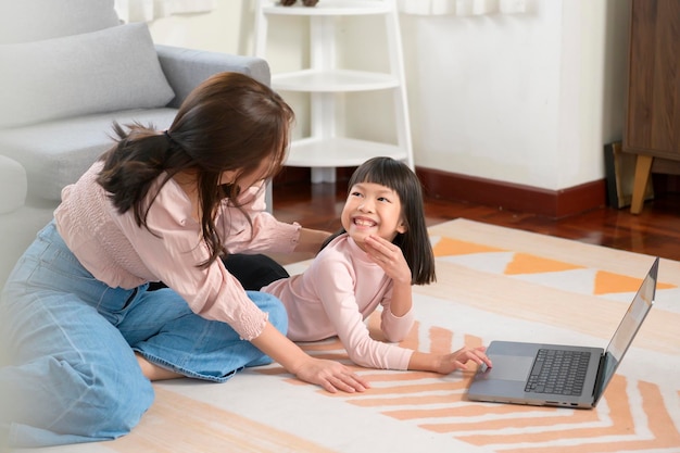 Família asiática com crianças usando laptop em casa