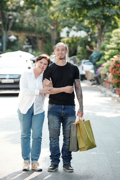 Familia asiática de dos caminando juntos por la calle con bolsas de compras después de ir de compras