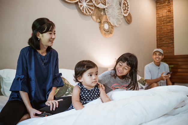 Família asiática feliz com dois filhos passando o tempo juntos no quarto