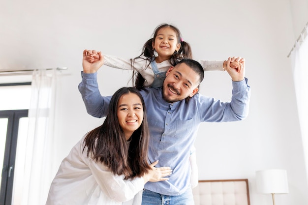 Família asiática feliz com uma filha pequena ficar em casa e se alegrar mãe e pai segurar a criança