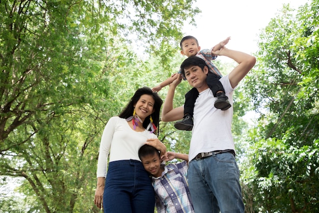 Família asiática feliz desfrutando de tempo para a família juntos no parque. conceito familiar