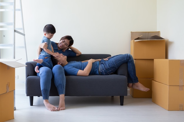 Familia asiática feliz divirtiéndose durante el día de mudanza y reubicación en el nuevo hogar. Mudanza y nuevo concepto inmobiliario