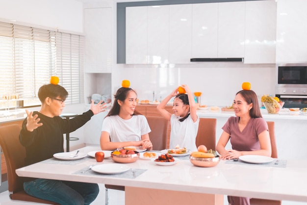 Familia asiática feliz enamorada comiendo comida juntos en casa