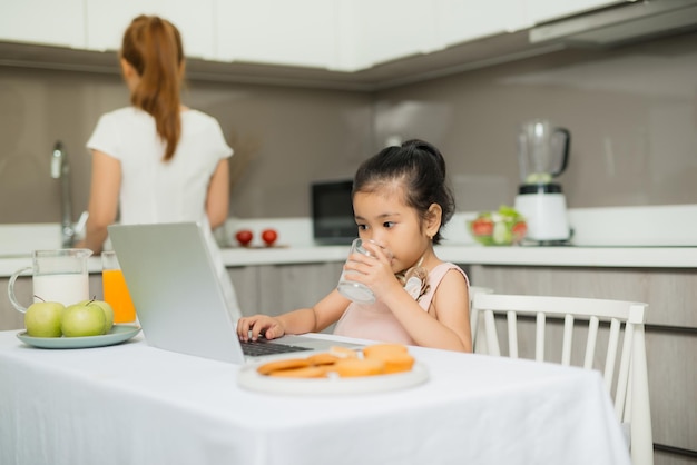 La familia asiática feliz está desayunando y ve una tableta digital en la cocina en casa Comida saludable y actividades matutinas