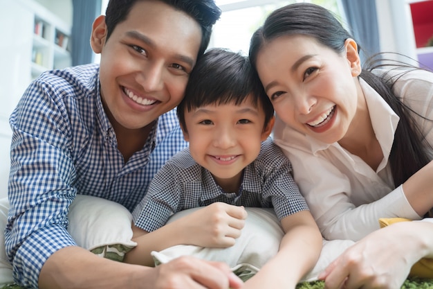 Foto família asiática feliz que passa o tempo junto no sofá na sala de visitas.