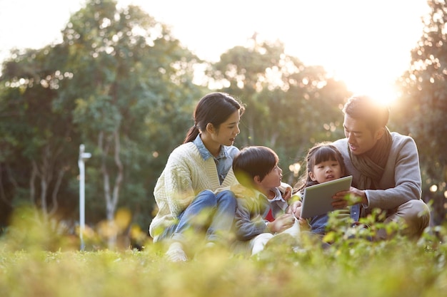 familia asiática feliz teniendo un buen tiempo al aire libre en el parque de la ciudad