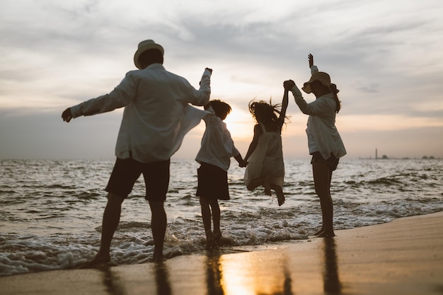 Família asiática feliz viaja na praia de férias