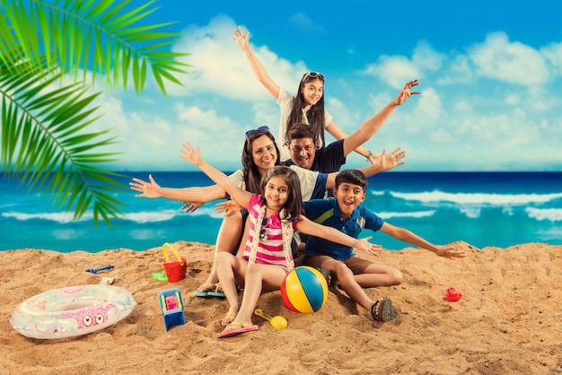 Familia asiática india disfrutando en la playa en verano