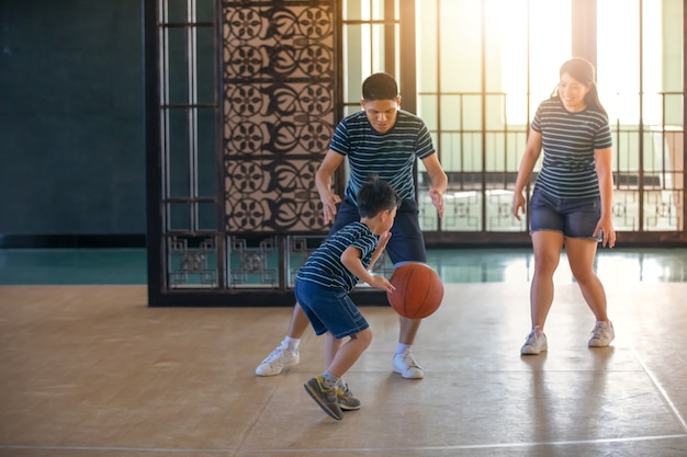 Familia asiática jugando al baloncesto juntos