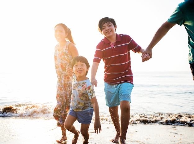 Familia asiática jugando en la playa