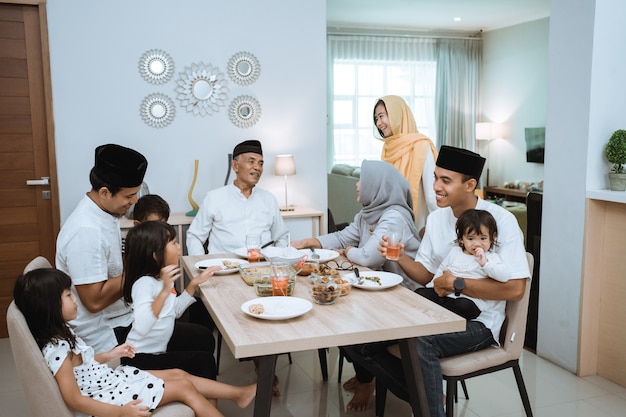 Família asiática muçulmana e avós, tendo o jejum de pausa no ramadã. intervalo para jantar iftar