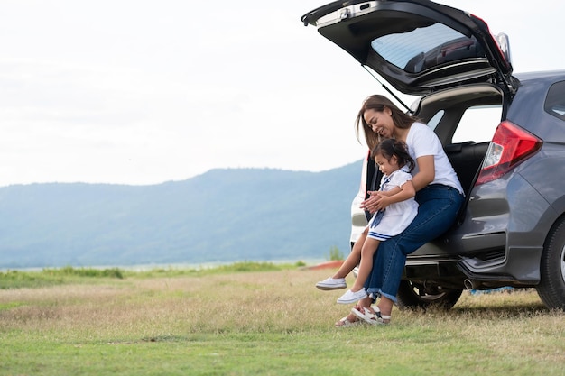 Foto familia asiática. niña feliz con familia sentada en el automóvil. concepto de seguro de automóvil