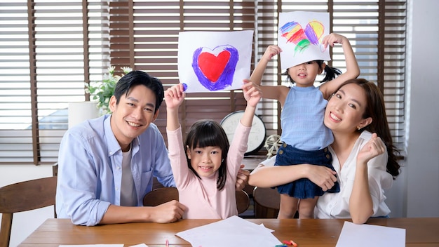 Familia asiática con niños Dibujar y pintar en la mesa en la sala de juegos en casa Juego educativo