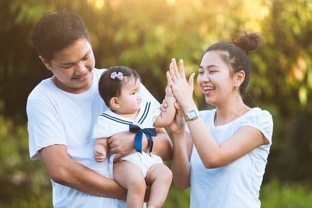 Família asiática pai mãe e filha brincando juntos no parque com amor e felicidade