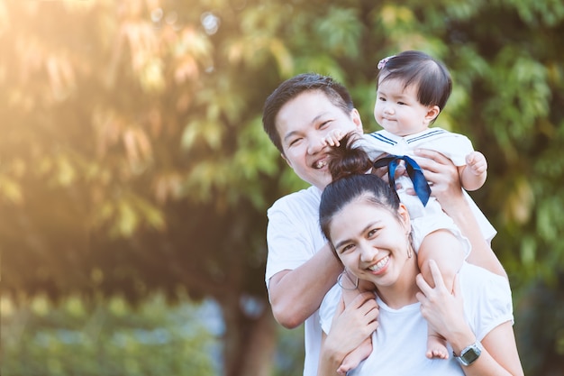 Família asiática pai mãe e filha brincando juntos no parque com amor e felicidade