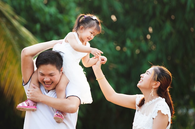 Família asiática pai mãe e filha brincando juntos no parque com amor e felicidade