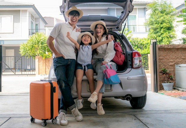 Foto família asiática pronta para começar a viajar de carro suv de casa com bagagem