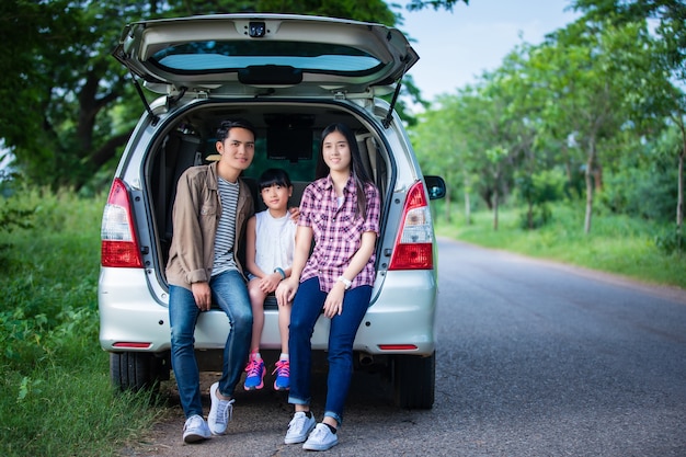 familia asiática sentada en el coche para disfrutar de un viaje por carretera