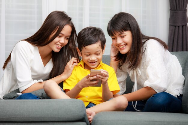 Familia asiática de tres niños, un niño y dos niñas están jugando juntos con la felicidad en casa