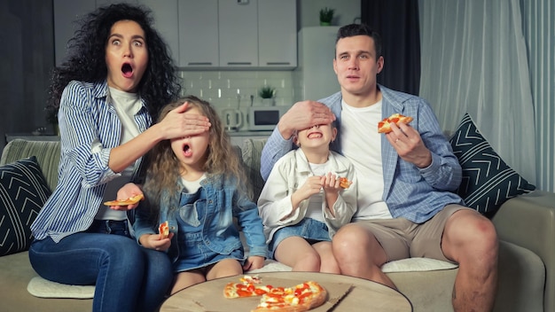 Família assiste filme de terror juntos e come pizza no sofá