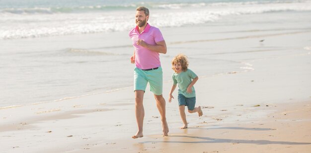 Família ativa de papai e menino correndo na praia juntos juntos