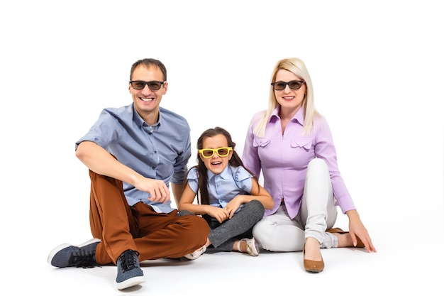 Família atraente assustada vestindo roupa casual isolada sobre fundo branco, assistindo a um filme com óculos 3d