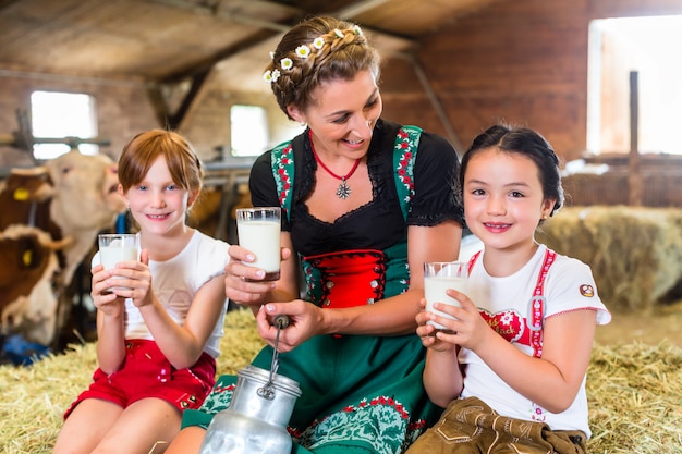 Familia Baviera bebiendo leche en establo de vacas