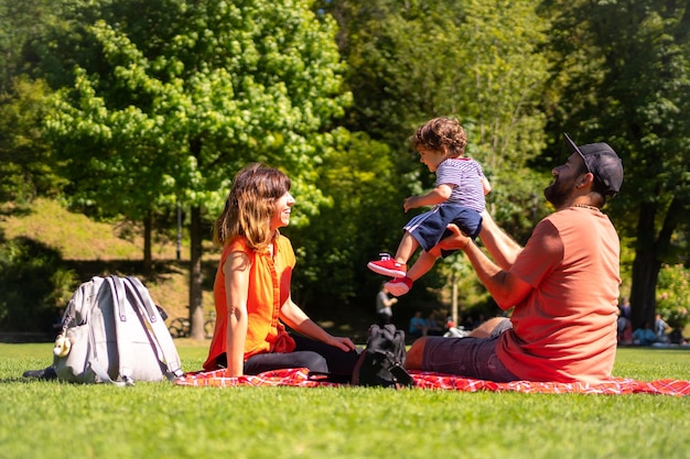 Familia con un bebé de un año divirtiéndose en un picnic en un parque