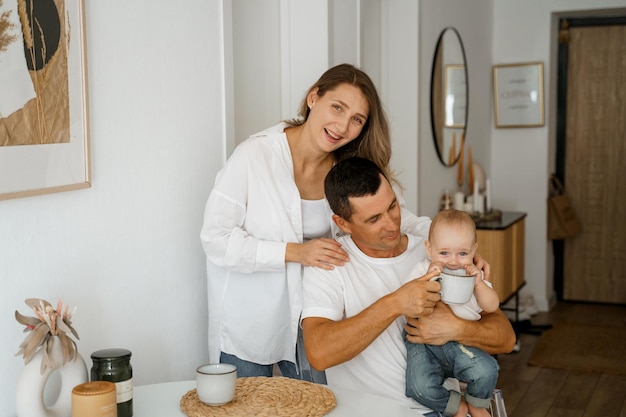 una familia con un bebé está desayunando en la cocina