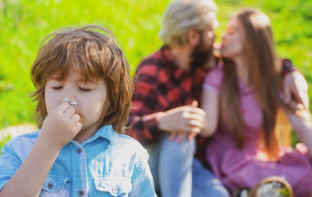 Família beijo feliz fazendo piquenique no jardim ou parque Jovem sorrindo lazer em família juntos dia ensolarado