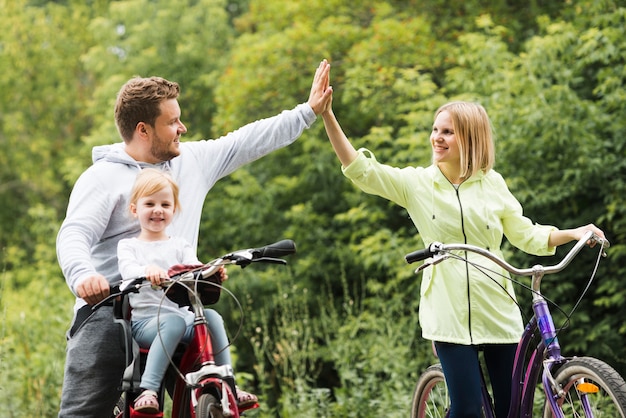 Familia en bicicleta dando alta cinco.